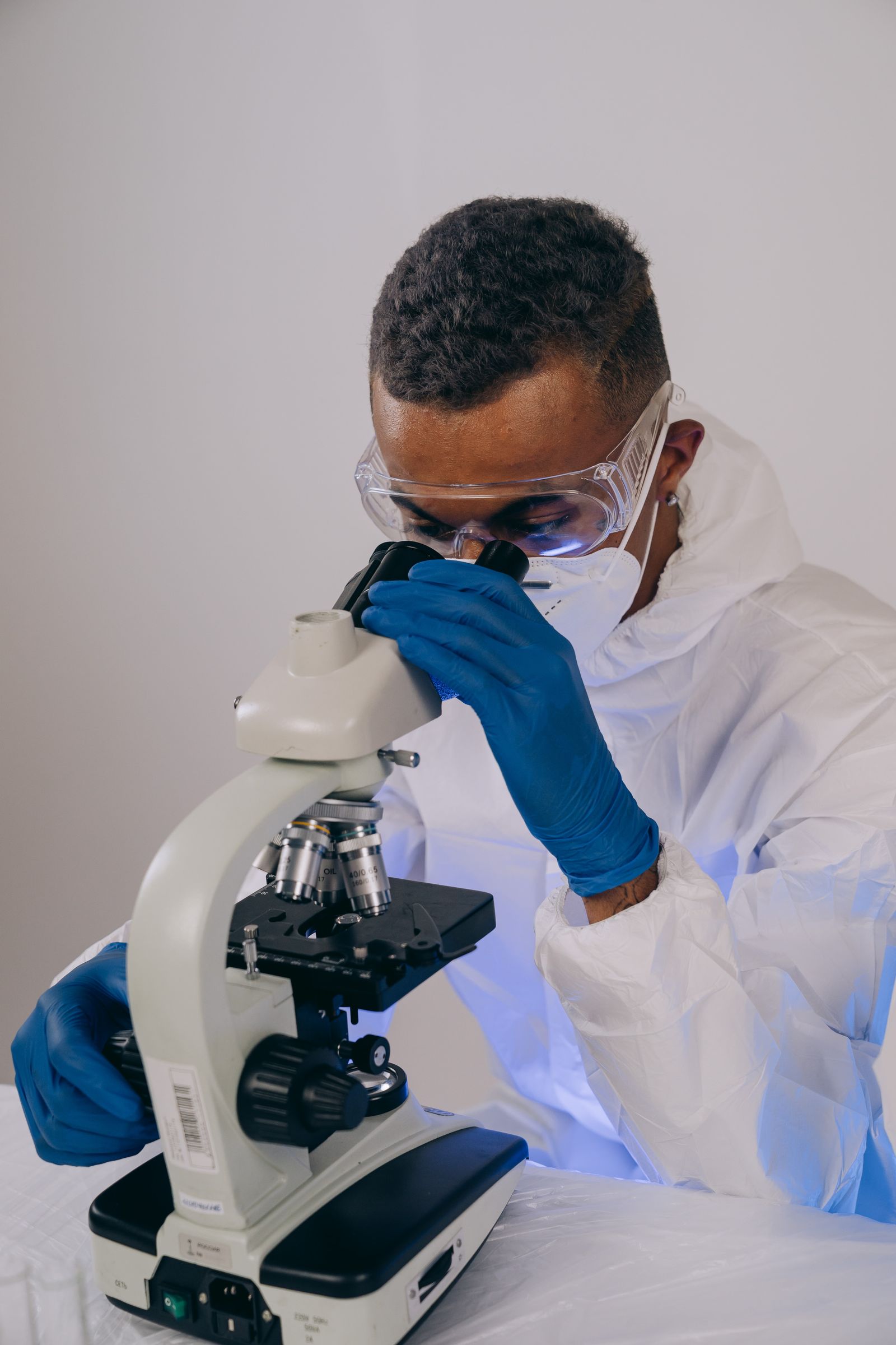 A scientist at a microscope, characterising a material
